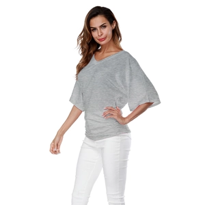 Detail of grey V-neck batwing sleeve top with side pleated gathering on soft knit fabric