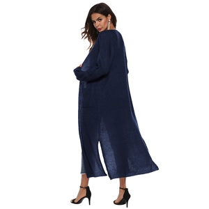 Detail view of a long navy knit cardigan with side slits and functional patch pockets