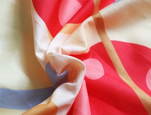 Detail of colorful geometric circular print fabric with soft folds for beach shawls