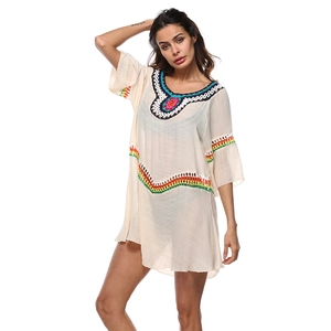 Gros plan sur les détails colorés au crochet de cette tunique de plage bohème blanche
