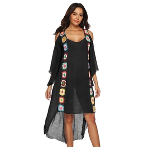Close-up of bohemian black beach dress featuring colorful hand-crocheted floral ribbons
