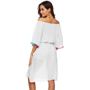 Vue détaillée du dos d'une robe de plage blanche à épaules dénudées et pompons colorés