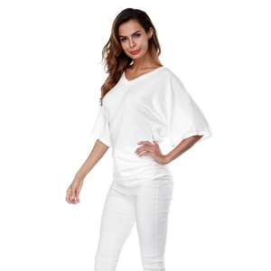 Detail of white V-neck top showing ruched side texture and loose batwing sleeve design