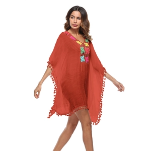 Dettaglio copricostume boho con scollo all'uncinetto e orlo con lunghe frange