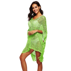 Detail of neon green crochet knit texture and tassel trim on oversized beach cover-up