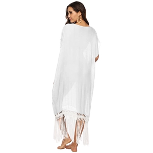 Detail showing the white bohemian beach dress with long fringe hem and crochet lace texture