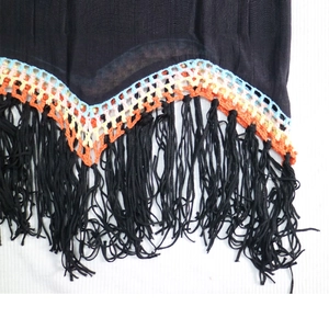 Détail d'un cache-maillot bohème avec bordure en crochet colorée et longues franges noires