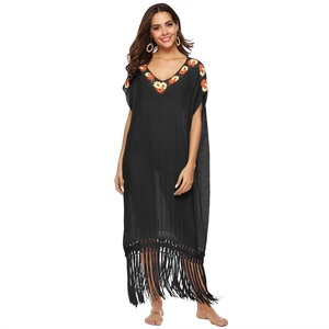 Detail of colorful bohemian embroidery on the V-neck of a black beach cover-up dress