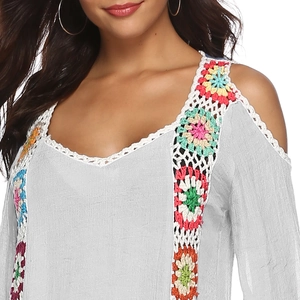 Detail of colorful crochet floral embroidery on a grey cold-shoulder beach tunic dress