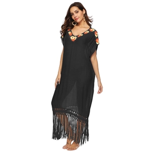 Detail of bohemian black beach cover-up featuring vibrant floral embroidery and fringe tassels