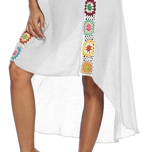 Detail of crochet floral accents and asymmetric hem on a sheer beach cover-up dress