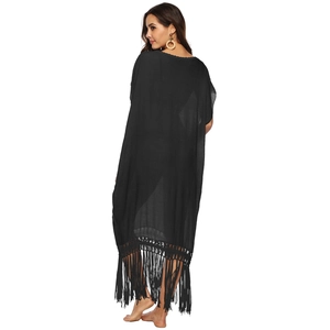 Detail of black bohemian beach cover-up featuring long tassel fringe and loose fit