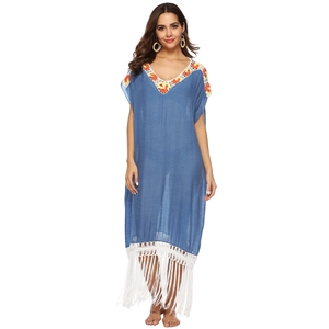Detail of blue crochet V-neck beach dress featuring vibrant orange and yellow embroidery