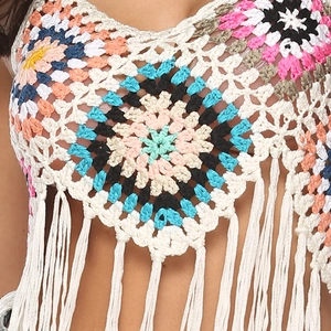 Detail of bohemian crochet pattern with colorful flowers and white tassels on a crop top