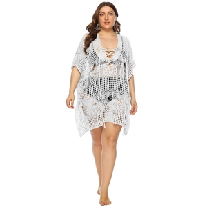 Close-up of white crochet knit beach cover-up featuring hollow-out geometric patterns