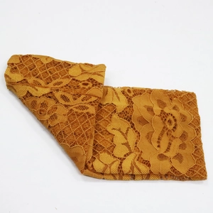Gros plan sur le bandeau en dentelle orange vif avec motifs floraux et texture ajourée