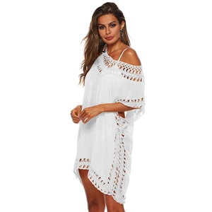 Gros plan sur le motif ajouré en crochet blanc et la texture d'une robe de plage