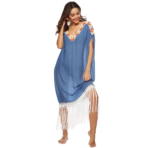 Detail of bohemian beach dress showing V-neck crochet patterns and long white tassels