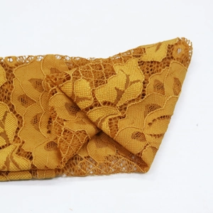 Gros plan détaillé du bandeau en dentelle jaune gingembre avec motifs floraux ajourés