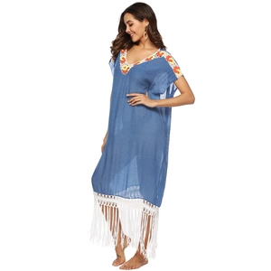 Detail of dark blue crochet beach dress featuring V-neck embroidery and long white fringes