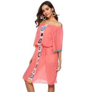 Détail de rayures au crochet colorées et de glands sur une robe de plage rose à épaules nues