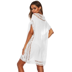 Détail latéral de la tunique de plage en crochet blanc montrant les motifs ajourés