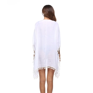 Dettaglio del copricostume bianco all'uncinetto con nappe decorative e tessuto leggero