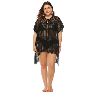 Close-up of black crochet beach cover-up featuring mesh structure and neckline tie detail
