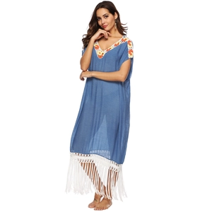 Detail of V-neckline with floral embroidery and white fringe on bohemian beach dress