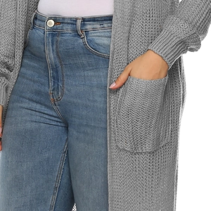 Dettaglio del cardigan grigio a maglia con tasca laterale e trama dei jeans in denim