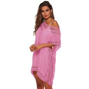 Détail de la tunique de plage rose ajourée avec broderies florales et bords en crochet