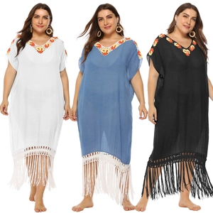 Detail of V-neck crochet embroidery and fringed hem on loose beach kaftan dress
