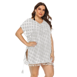 Detailed view of white chiffon beach cover-up featuring pom-pom texture and tassel hem