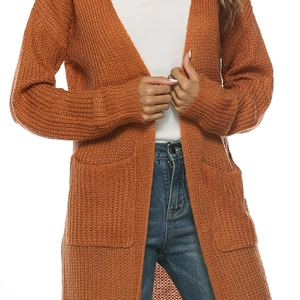 Detail of caramel knit cardigan featuring functional side pockets and ribbed cuffs