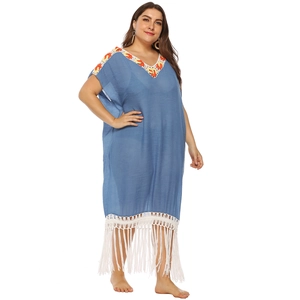 Detail of blue plus size beach dress with orange crochet V-neck and white tassel hemline