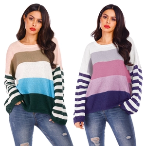 Close-up of color-block striped knitted sweaters in diverse pastel and neutral tones