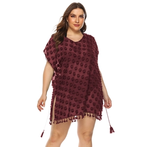 Detail showing deep red chiffon beach dress with polka dot texture and fringe hemline