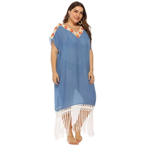 Detail of bohemian crochet embroidery on the V-neckline of a light blue beach dress