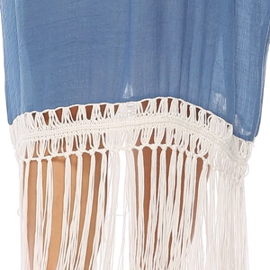 Macro detail of bohemian blue dress featuring white crochet lace and long fringe hem