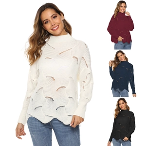 Detailed view of the intricate pointelle knit texture and wavy hem on this turtleneck sweater