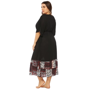 Vue latérale d'une robe noire grande taille avec ourlet imprimé ethnique et manches chauve-souris