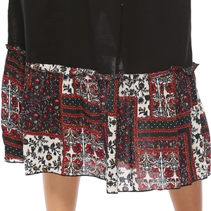 Détail de l'ourlet à volants avec imprimé floral bohème sur la robe longue noire