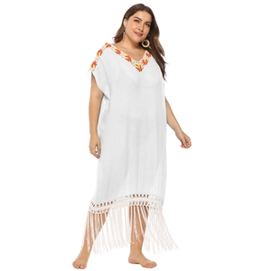 Detailed view of bohemian white beach dress with colorful crochet trim and long tassels