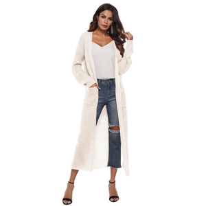 Detail of long beige knit cardigan with large side pockets and ribbed texture
