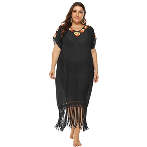 Detail of colorful embroidery on V-neckline and fringe hem of black kaftan dress