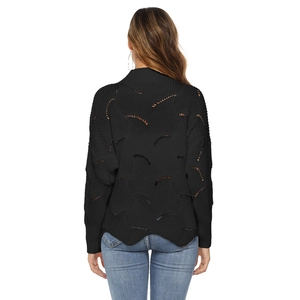 Detail of black pointelle knit sweater featuring intricate wavy patterns and hollow design