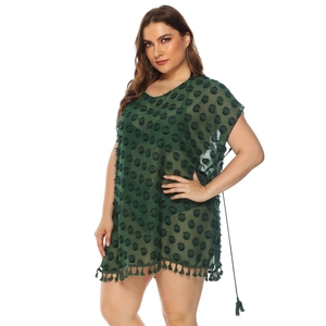 Detail of dark green chiffon beach dress featuring textured polka dots and tassel fringe