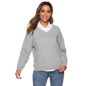 Detail of light grey V-neck knitted sweater featuring fine ribbed cuffs and woven texture