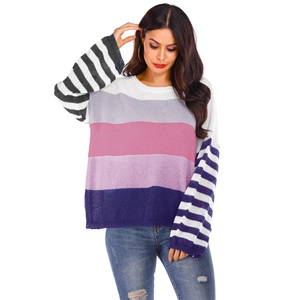 Detail of color-block oversized knit sweater with multi-color stripes and textured fabric