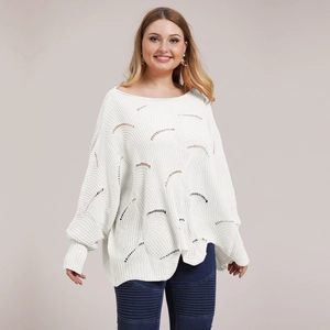Detailed view of white oversized knit sweater featuring wavy hollow-out crochet texture